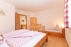 Dreibettzimmer mit Gitterbettchen